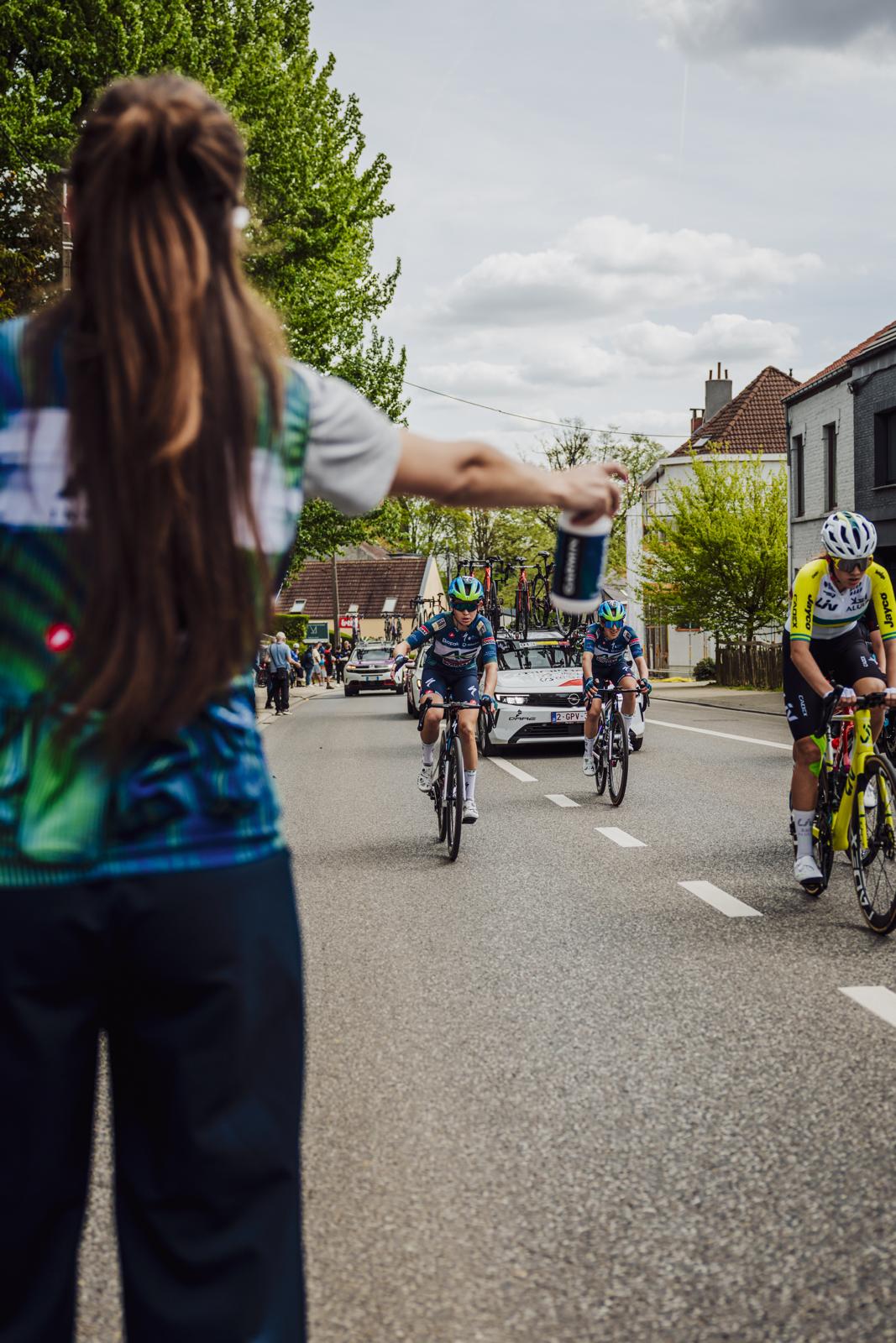 Jessica Van Melkebeke reikt bidons aan tijdens de bevoorrading